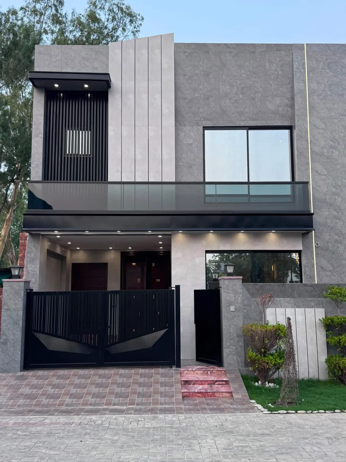 Modern 5 marla double-storey house in Lahore with grey stone elevation and black gate